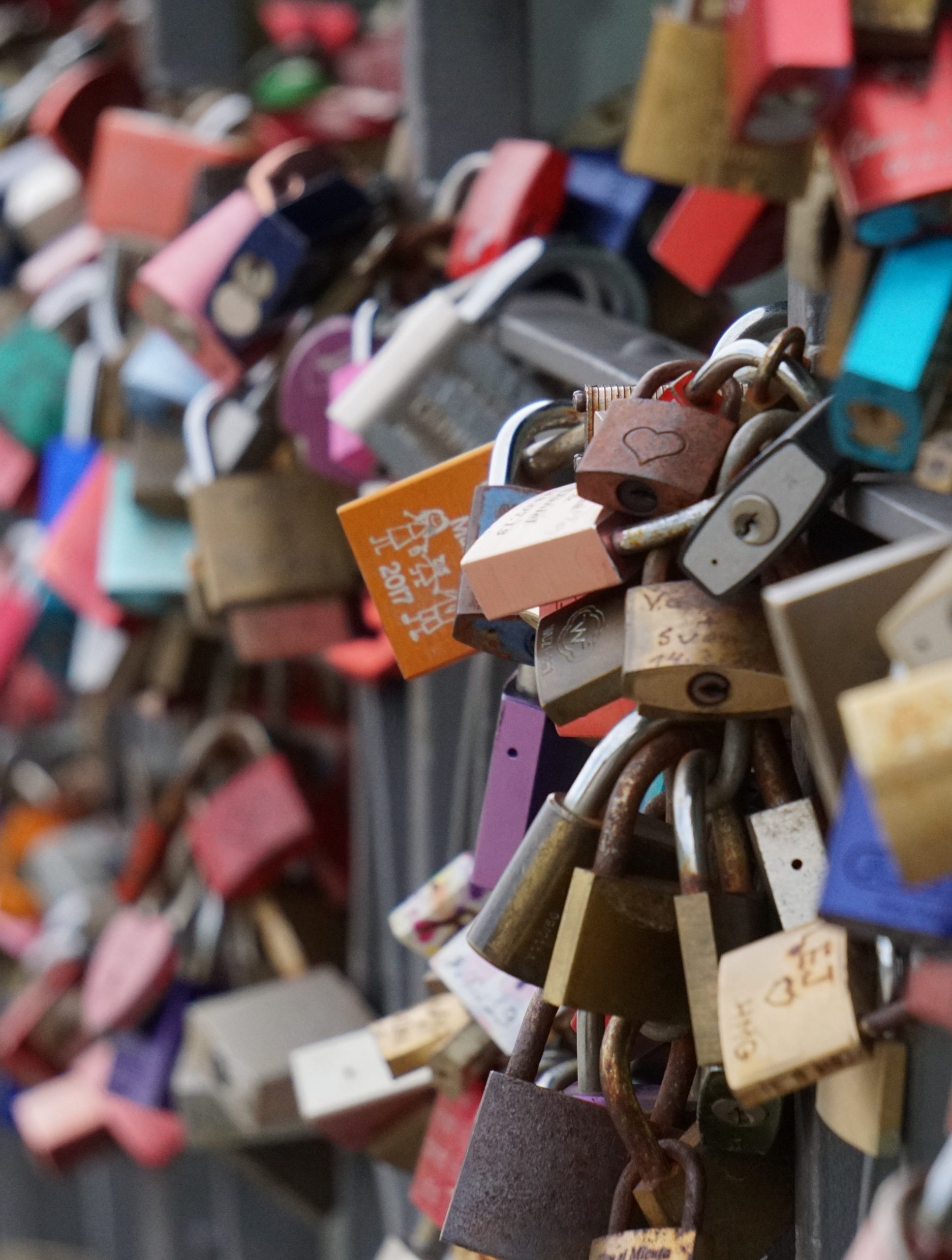 Dozens of colorful locks attached to a fence