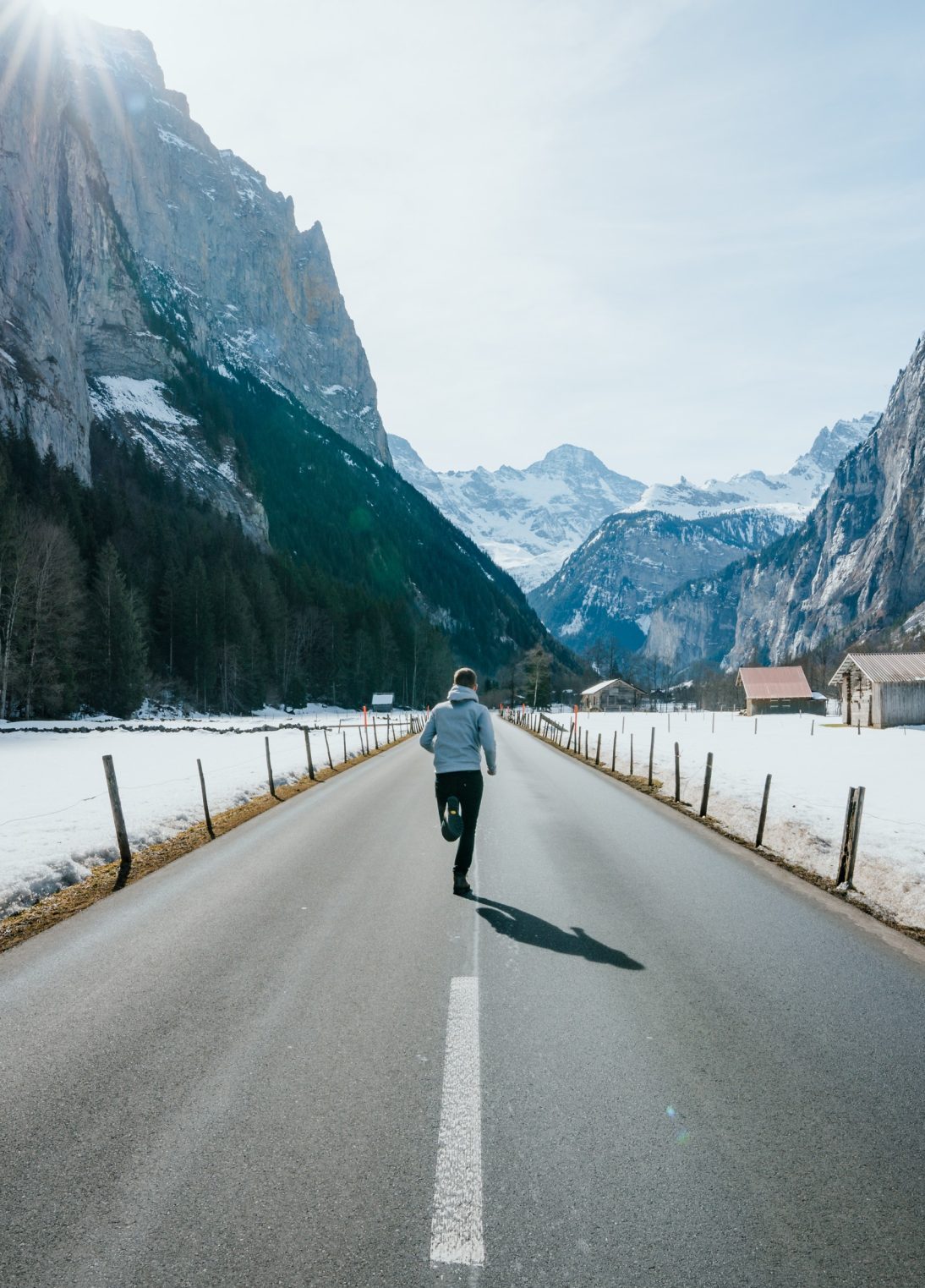 Runner on an empty road in a beautiful mountain scenery